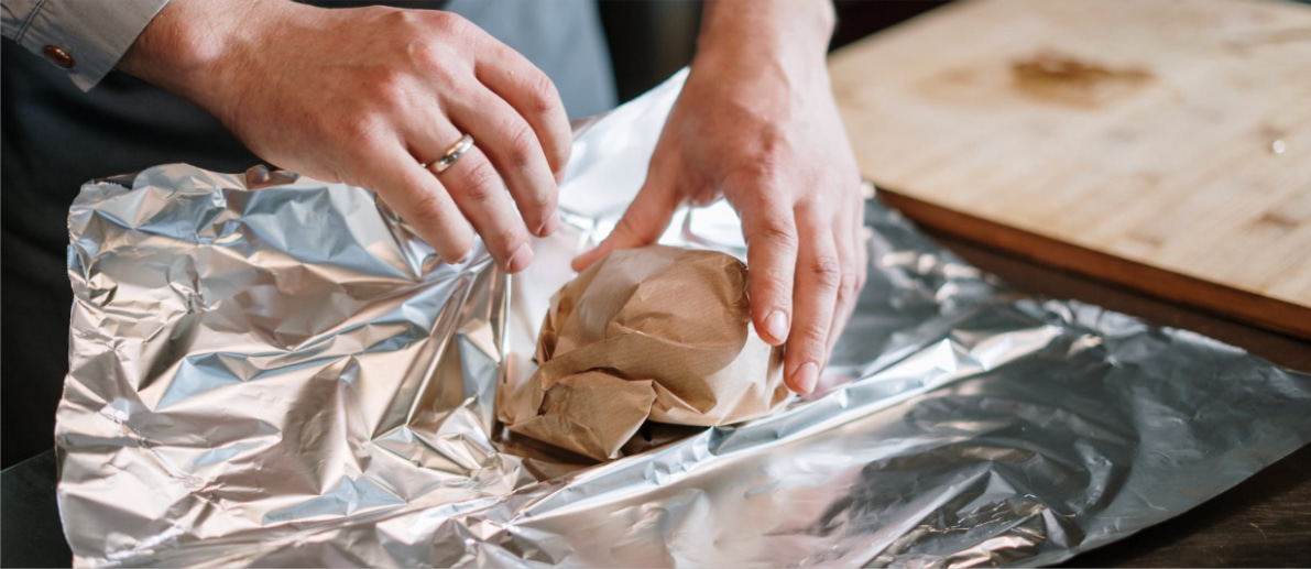 Person wrapping paper and foil